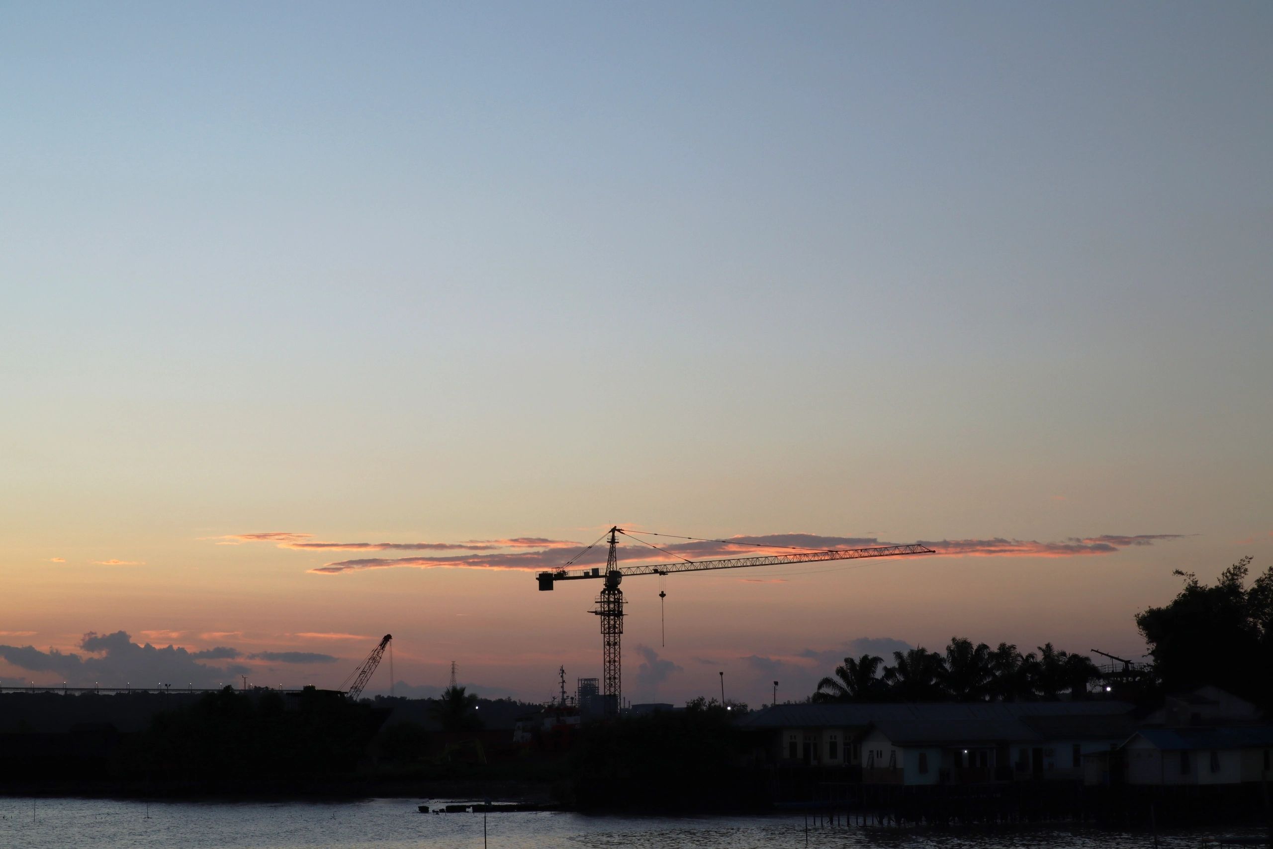Grúa e infraestructura bajo un cielo al atardecer